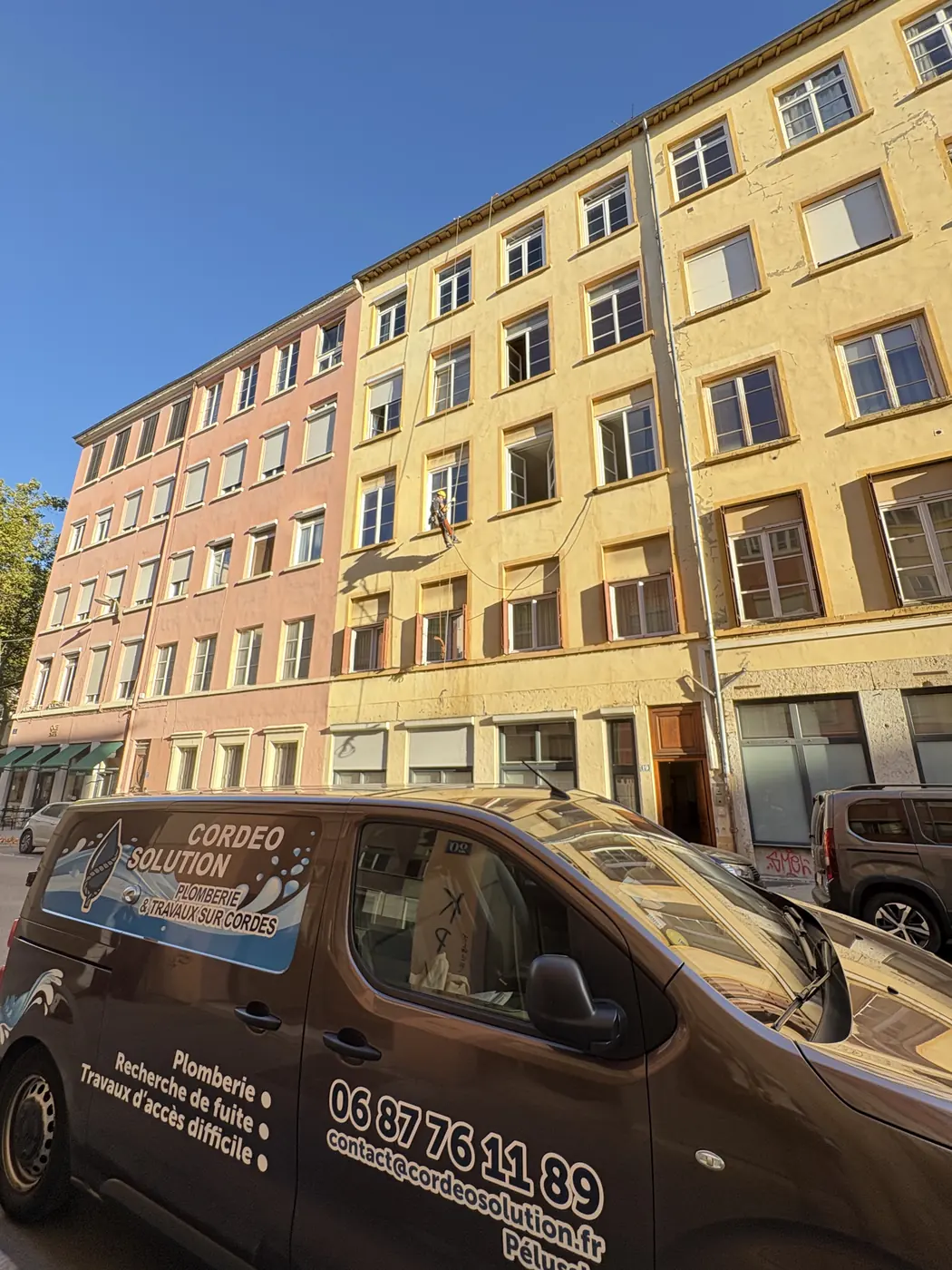 Utilitaire Cordeo Solution devant une façade d'immeuble